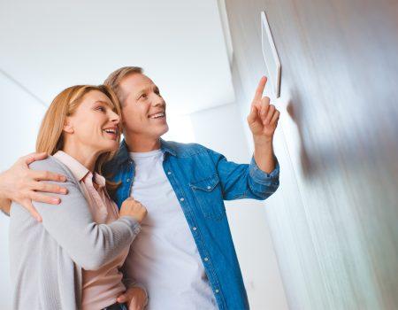 couple smiling using tablet for Smart Home Automation in Alpharetta, GA